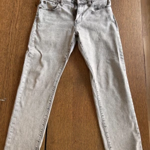 Levi's 502 ljusgrå jeans W30 L30 - Säljer ett par Levi's 502 Premium jeans i ljusgrå tvätt. Klassisk femficksmodell med dragkedjegylf och snyggt läderpatch bak. Jeansen är raka med en något smalare passform och tillverkade i bomull. Perfekta för dig som gillar stilrena och bekväma jeans.