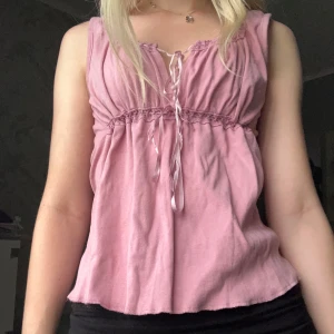 Rosa linnetopp med snörning B-Young - Supersöt ljusrosa linnetopp från B-Young med smockdetaljer under bysten och dekorativ snörning framtill. Toppen har en avslappnad passform💕 Storlek M men passar på mig som har xs-s. Skriv vid frågor💕