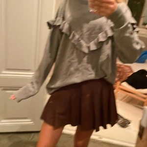 Brun plisserad kortkjol - Jätte söt skol vibes 💕😇 Snygg brun plisserad kortkjol med klassisk siluett. Kjolen har tydliga veck och sitter högt i midjan. Perfekt för dig som gillar en trendig och stilren look. Kjolen är helfärgad utan mönster. En fläck. 