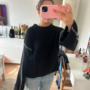 Svart stickad tröja med vita ”stygn” - Säljer en svart stickad tröja med breda ärmar och vita  sömmar, bra skick 