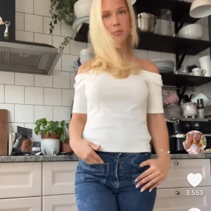 Vit ribbad offshoulder topp - Säljer en fräsch vit ribbad topp med offshoulder-design och korta ärmar. Toppen är figurnära och har en snygg, enkel look som passar perfekt till jeans eller kjol. Materialet är stretchigt och bekvämt, vilket gör den lätt att bära hela dagen.