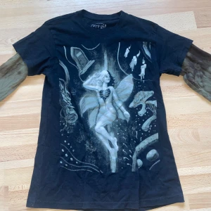 Melanie Martinez Portals 2 in 1 long sleeved t shirt - Katt och hund finns i hemmet men självklart så tvättas tröjan innan frakt. Storlek S. Originalpris 622kr (går ej att köpa längre) Från hennes officiella hemsida i November/December 2023. Har två st fläckar på vänster ärm. Använd fåtal gånger. 