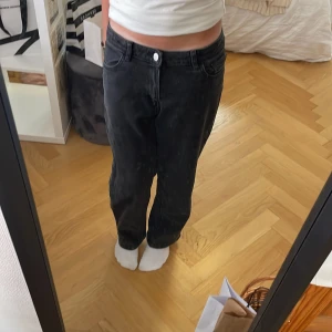 Svarta baggy jeans från Lindex - Säljer ett par svarta jeans från Lindex med rak passform och klassisk femficksdesign. Jeansen har hög midja men man kan även ha de som lägre och är tillverkade i ett mjukt bomullstyg med lite stretch. Använda typ 1-2 gånger.