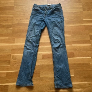 Blå bootcut jeans från Zara, strl 36 - Snygga blå jeans från Zara i klassisk bootcut-modell. Jeansen har normal passform, fem fickor och är tillverkade i mjukt bomullsjeansmaterial. Har slitit upp längst ned på kanten av jeansen, men ser nästan ut som en detalj på dem (se bild 3). 