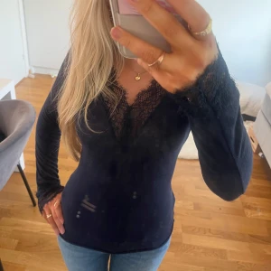 Intermissmi tröja med spets  - Säljer en mörkblå intermissimi topp med v-ringning och fina spetsdetaljer vid halsringning och ärmslut. Tunn och stretchig modell som sitter tight mot kroppen. Original priset är ca 500, jag har använt den fåtal gånger och den är i nytt skick 