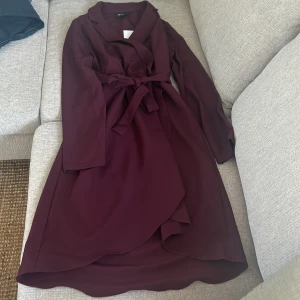 Vinröd omlottklänning från Object - Säljer en vinröd omlottklänning från Object med knytband i midjan. Perfekt för dig som vill ha en stilren och tidlös look. Kan också användas som en kappa men obs. Är lite tunnare material så för varmt väder.priset går att diskutera 💕
