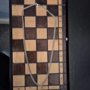 Silverkedja - Stilrent halsband i sterling silver (GHA 925) med klassisk pansarlänk och karbinhake. Passar perfekt för dig som gillar enkel och tidlös design. Länken är medelbred och ger ett snyggt intryck både till vardags och till mer uppklädda tillfällen. 