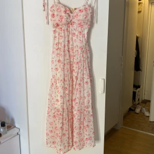 Blommig långklänning - En vit rosa blommig långklänning, aldrig använda bara testad 