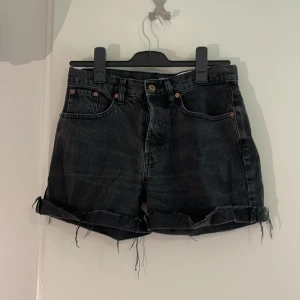 Jeansshorts - Säljer ett par svarta jeansshorts med fransig kant nertill. Stilren!! Varken låg eller högmidjad