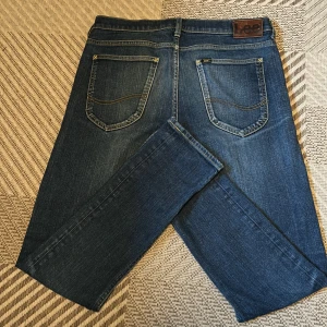 Mörk Blåa jeans från Lee - Säljer ett par klassiska blå jeans från Lee. Små täcken av användning 