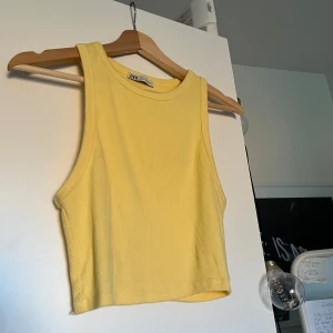 Gul ribbad croppad linnetopp från Zara - Säljer en ljusgul ribbad croppad linnetopp från Zara. Toppen är ärmlös och har en rund halsringning. Stl M, men även väldigt stretchigt. Enbart använt fåtal gånger, så mycket bra skick. Kontakta gärna vid mer information och mer exakta mått. Säljer samma på vinted så hör gärna av er innan köp!