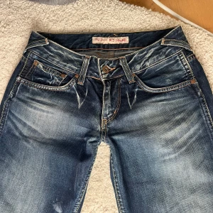 Lågmidjade Jeans - Lågmidjade utsvängda jeans från Pepe Jeans i storlek XS/S. Midjemåttet är 34cm tvärsöver och innerbenslängden är 77cm❣️  Har en fläck (se sista bild) men annars gott skick!!