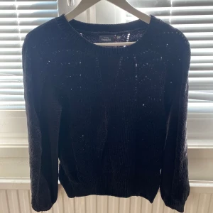 Svart stickad tröja från KappAhl - Mysig svart stickad tröja från KappAhl i storlek XS. Tröjan har rund halsringning och långa ärmar, perfekt för kyligare dagar. Enkel och stilren design som passar till det mesta.