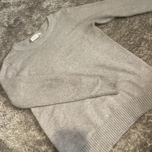 Ljusgrå stickad tröja från Vila - Ljusgrå stickad tröja från Vila med rund halsringning och ribbade muddar vid ärmslut och nederkant. Tröjan är i bra skick med små defekter. Pris kan diskuteras 💗