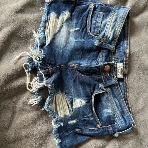 lågmidjade shorts - Säljer dessa lågmidjade korta jeansshortsen från Bershka i storlek 32, midjemåttet är 35 cm rakt över. Supersnygga! Skriv om du undrar något, passar även 34! Pris kan diskuteras!💖