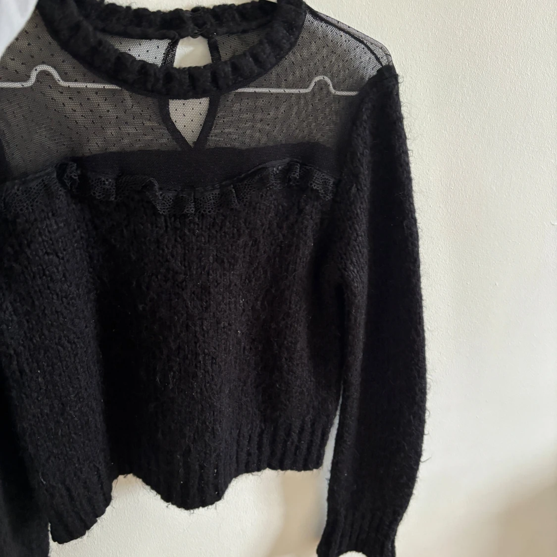 Svart stickad tröja med mesh och volang