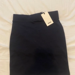 Marinblå kjol från Bik Bok - En klassisk marinblå kjol från Bik Bok midja rak passform. Kjolen är enkel och stilren, perfekt att matcha med olika toppar. Materialet känns mjukt och har en lätt stretch. Ny pris: 199kr