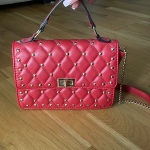 Valentino liknande väska - super snygg röd valentino liknande väska med guld detaljer och nitar! Använd fåtal gånger men inga skador har gjorts!