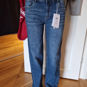 Blå raka jeans  - Säljer ett par oanvända klassiska blå jeansbyxor från LMTD, nameit med regular fit. Byxorna har fem fickor, dragkedja och knapp framtill samt raka ben och justerbar midja. På bilden: 14 år och har annars storlek XS. Nypris 530 kr. Mitt pris 400 kr.