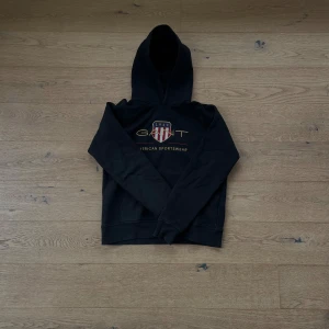 Gant hooodie - En stilren hoodie med klassisk mörkblå färg, passar perfekt nu inför sommarn och svala utekvällar🙌 knappt använd och har inga produktfel. Jag säljer för 650 och nypris ligger en sådan här hoodie runt 800.