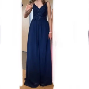 Blå balklänning från Mascara London - Elegant marinblå balklänning från Mascara London med spetsdetaljer och paljetter på överdelen. Klänningen har smala axelband och en vacker v-ringning. Endast använd 1 gång, på 9:ans bal, så väldigt bra skick💙Jag är 166 och har oftast S, den passar bra och är bra i längden, pyttelite lång. Köpt för ca 1600kr på Zalando. Om du vill ha fler bilder eller har frågor kontakta mig!