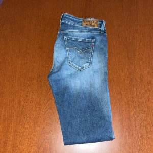 Blå Replay jeans  - Säljer ett par klassiska blå jeans från Replay. Jeansen har fem fickor, tydliga kontrastsömmar och läderpatch med Replay-logga bak i midjan. Perfekta för en avslappnad stil.