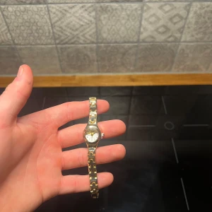 Guldklocka  - Helt oanvänd klocka med justerbart armband och nytt batteri. Den är gjort av 100% rostfrittstål. Armbandet justera du lätt hemma med hjälp av en nål. 