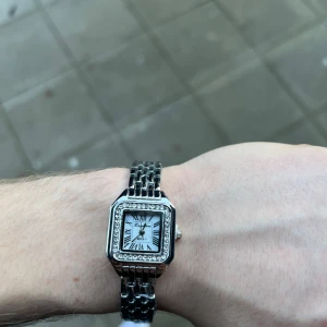 Silverklocka  - Helt oanvänd klocka med justerbart armband och nytt batteri. Den är gjort av 100% rostfrittstål. Armbandet justera du lätt hemma med hjälp av en nål.