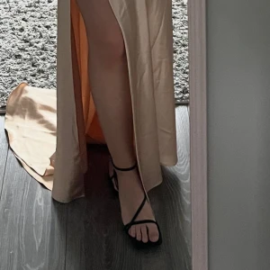 Svarta sandaler med klack och tunna remmar - Säljer ett par eleganta svarta sandaler med smal klack och tunna remmar över foten och runt vristen. Perfekta för dig som vill ha en stilren och trendig look. Passar till både klänning och byxor. Klackhöjd 10 cm, aldrig använda