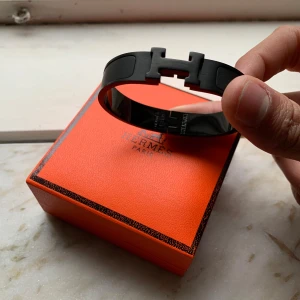 Svart Armband - Säljer ett riktigt stiligt svart armband. Armbandet är helt nytt aldrig använd i metall och kommer med originalask och påse. Perfekt accessoar för att lyfta din outfit. Vid frågor eller funderingar skicka ett pm, Mvh