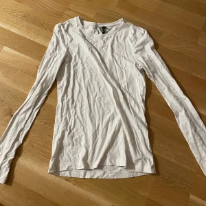 Vit långärmad tröja från Pieces - Säljer en enkel och stilren vit långärmad tröja från Pieces. Tröjan har rund halsringning och är tillverkad i mjuk bomull, perfekt för lager-på-lager eller som basplagg i garderoben.