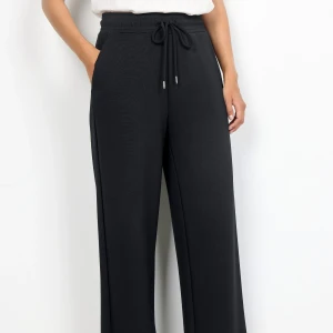 Svarta mjukisbyxor med dragsko - Svarta mjukisbyxor med breda ben och dragsko i midjan. Byxorna har en avslappnad passform och är perfekta för en chill stil. Tillverkade i mjukt material som känns skönt mot huden.