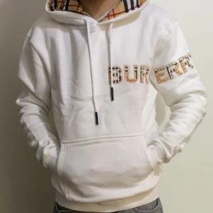 Vit Burberry - Säljer en vit hoodie från Burberry med klassiska rutiga detaljer i luvan och på bokstäverna. Tröjan har magficka och dragsko i huvan. Perfekt för dig som gillar stilrena och exklusiva plagg. Den kommer vara bra inför sommaren , priset kan diskuteras i en snabb affär