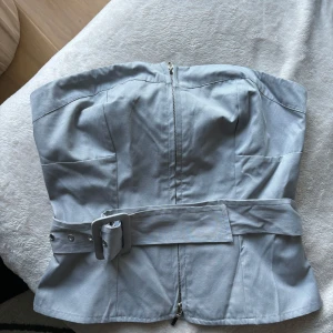 Ljusgrå tubtopp med bälte  - Säljer en ljusgrå tubtopp från Forever 21! Supersnygg till lite festligare tillfällen 💃🏼 endast använd en gång 💕