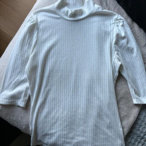 Vit ribbad polotröja från Lindex - Säljer en vit ribbad polotröja från Lindex i storlek S. Tröjan har lång ärm och hög krage, perfekt för lager-på-lager eller som den är. Enkel och stilren design som passar till mycket. Superfin 🤍