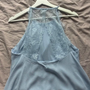 Ljusblå topp med spets från Samsøe Samsøe - Supersöt ljusblå linnetopp från Samsøe Samsøe med tunna axelband och vacker spetsdetalj i ryggen. I princip ny! Andra bilden är likadan topp men i mörkblå (säljer även den)