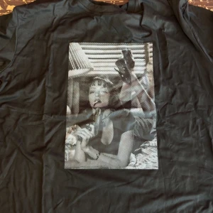 Svart t-shirt med grafiskt tryck - Cool svart t-shirt med ett stort grafiskt tryck i svartvitt framtill. Klassisk passform och rund halsringning, perfekt för dig som gillar streetstyle och unika motiv. Materialet känns mjukt och skönt mot huden.