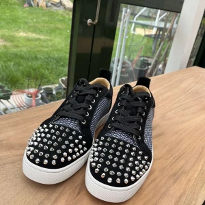 Christian Looboutine - Tja säljer dessa feta svarta Christian Louboutine skor med silverfärgade nitar på tån och sidorna. Det är storlek 43. Skorna är i väldigt bra skick och har inga defekter och är 10/10. Allt og ingår! Kontakta mig gärna om frågor!