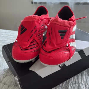 Adidas Predator PRO fg röda fotbollsskor - Snygga Adidas Predator fotbollsskor i rött med vita och svarta detaljer. Skorna har snörning, täckt  Tillverkade i syntetmaterial med klassiska tre ränder på sidan och Predator-logga. Perfekta för dig som vill sticka ut på matchen. Säljer för kunde inte lämna tillbaka de för de är använda en gång, köpta på stadium.