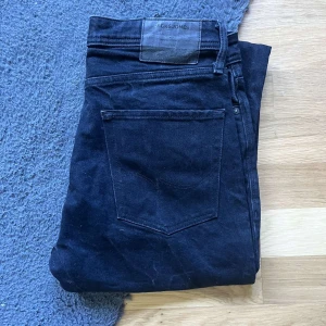 Svarta jeans från Jack & Jones - Säljer ett par svarta jeans från Jack & Jones med klassisk femficksdesign och raka ben. Jeansen har en mörk tvätt och är tillverkade i bomullstyg med en snygg, enkel look. Perfekta för dig som gillar stilrena och tidlösa jeans. Längd 102cm Jag skickar ej bild när jag bär plaggen och jag vet ej vilken längd och vikt de passar då jag inte prövar kläderna jag säljer 😃
