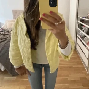 Gul quiltad pufferjacka - Säljer en ljusgul quiltad pufferjacka med loose passform. Jackan har trekvarts ärm och är perfekt för dig som vill ha en lätt och trendig jacka till vår eller höst. Enkel att matcha med jeans eller kjol för en chill look. Säljer för den inte passa mig. 