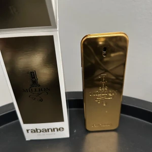 Paco Rabanne 1 Million EdT 100ml nypris 1099 från kicks  - 1 Million Eau de Toilette från Paco Rabanne i en ikonisk guld- och svartfärgad flaska på 100 ml. Flaskan har en lyxig metallisk finish och rektangulär form med präglad logga. Doften är känd för sin fräscha, kryddiga och maskulina karaktär. Helt ny inte ens sprayad en enda gång.