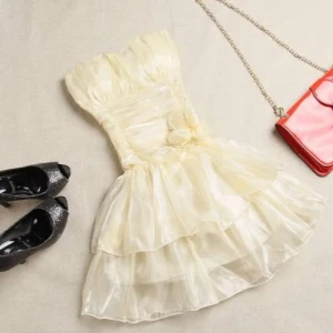 Axelbandslös volangklänning  - Axelbandslös kortklänning med volanger i flera lager och markerad midja. Klänningen finns i champagne, ljusrosa och stark rosa. Materialet är glansig satin och modellen har en dekorativ rosett framtill. Perfekt för dig som vill sticka ut med en feminin och trendig look. 359kr/st , helt ny 