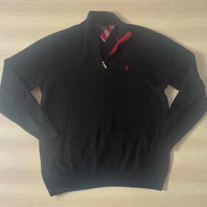 Ralph lauren -  Polo Ralph Lauren Tröja – Storlek L 🔹 🔥 Klassisk och stilren zip-tröja från Ralph Lauren!  🔸 Storlek: L 🔸 Svart med röd och grå detalj på insidan av kragen 🔸 Broderad röd logga på bröstet 🐎 🔸 Utan prislapp men helt i fint skick – användbar till både vardag & finare tillfällen 🔸 Mjuk och bekväm kvalitet 🔸 Passar perfekt till höst, vinter eller kyliga sommarkvällar  📦 Skickas samma dag! 💰 Pris: 350 kr  Skriv vid intresse! 📩