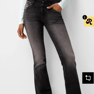 Svarta bootcut jeans med hög midja - Snygga svarta bootcut jeans med hög midja och knäppning framtill. Jeansen har en lätt tvättad look och sitter tajt upptill med utsvängda ben. Perfekta för dig som gillar en trendig och bekväm stil.