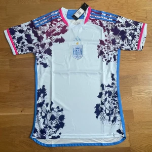 Spain team 23 away jersey - Stilren bortatröja för Spaniens landslag 2023. Tillverkad i lätt, ventilerande material med AEROREADY-teknologi som håller dig sval och bekväm. Perfekt för både träning och vardag