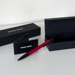 Röd kulspetspenna Explore Ballpoint Pen - En helt ny och oanvänd Hugo Boss Explore Ballpoint Pen i färgen Brushed Red!! ✍🏼🌹En elegant och stilren kulspetspenna från Hugo Boss, perfekt som present eller för dig som uppskattar lyx. Pennan är röd med metalliska detaljer, ligger skönt i handen och skriver mjukt. 🏷️Nypris från 1000 till 4000 kr. Priset kan diskuteras.