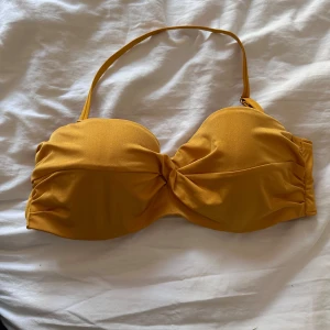 Bikini överdel - En gul bikini överdel, som man kan ta bort axelbandet på.