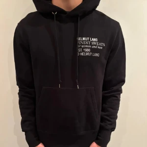 Svart Helmut Lang hoodie - Säljer en fet hoodie från Helmut Lang i svart färg. Passar till flera olika outfit och har skönt material. Skick 9,5/10 använd fåtal gånger. Hör gärna av er om ni har några funderingar!