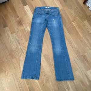 Blåa jeans - Supersnygga lågmidjade bootcut jeans i färgen blå! Vintage och går inte att få tag på längre! Storlek 26, midja: 36 cm, midjehöjd: 18 cm, innerben: 83 cm